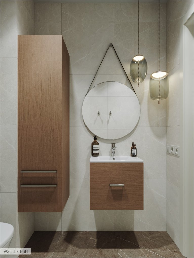 Round mirror in the bathroom with a hanging cabinet for bath accessories.
