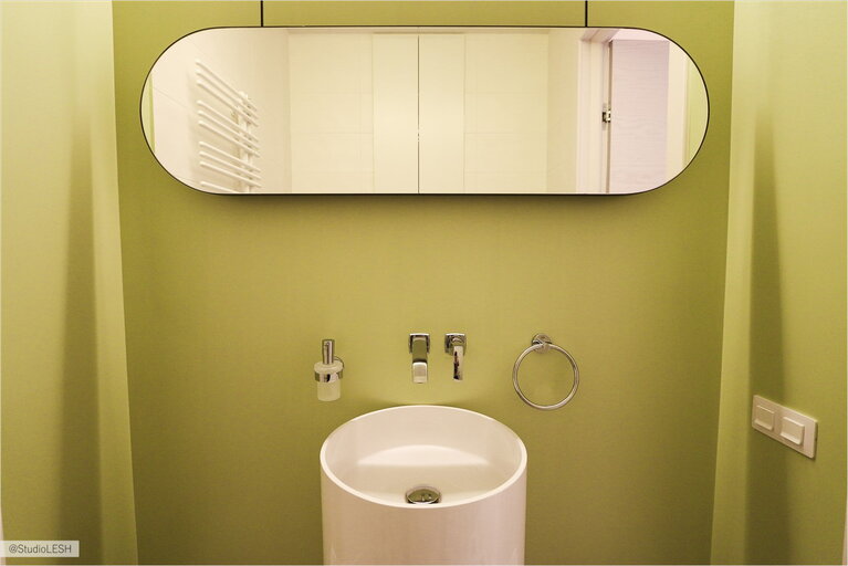 Ярко-зеленая ванная комната с интересным решением для раковины и зеркала