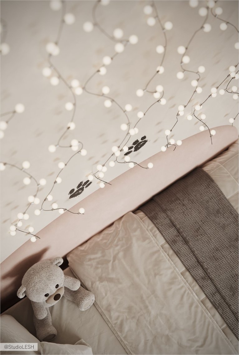 Интерьер детской комнаты с белой кроватью, украшенной гирляндой с огоньками, и мягкой игрушкой на кровати.