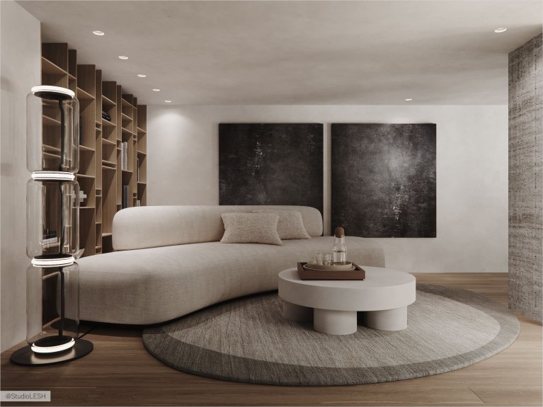 Интерьер современной гостиной с белым диваном, серым креслом, круглым столиком, торшером и большим книжным шкафом на заднем плане.