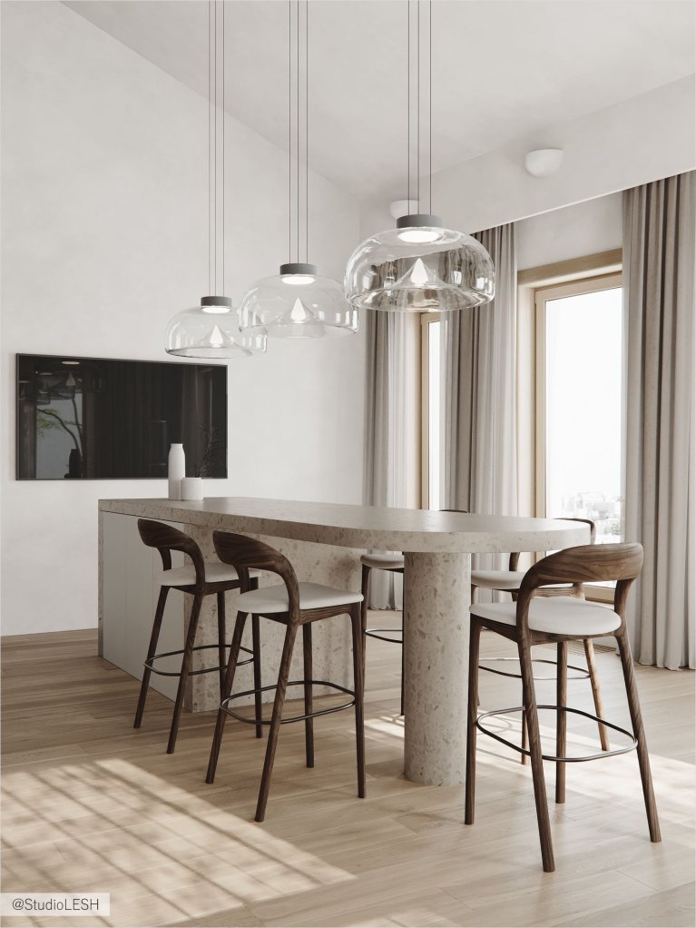 Интерьер современной кухни с белыми шкафами, каменной столешницей, деревянными стульями у барной стойки и тремя подвесными светильниками над ней