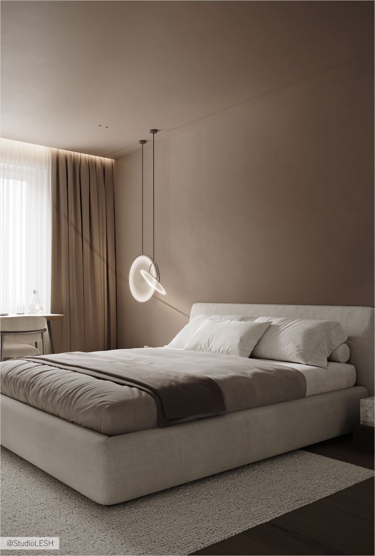 Уютная спальня с кроватью, на которой лежит мягкое покрывало и подушки. Рядом с кроватью стоит рабочий стол с ноутбуком, а над ним свисает стильный светильник. В комнате преобладают теплые оттенки, создающие атмосферу комфорта и спокойствия.