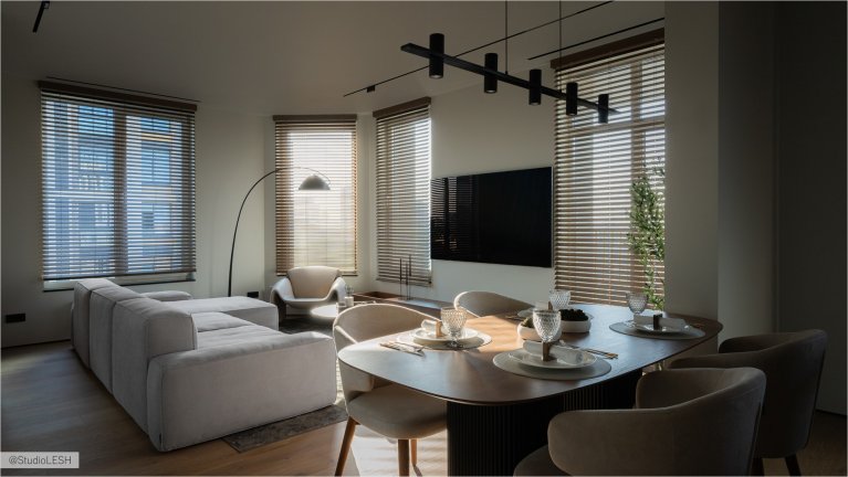 Интерьер гостиной в светлых тонах с мягким диваном, обеденным столом со стульями, разделяющим пространство стеклянной перегородкой, и плотными шторами на окнах