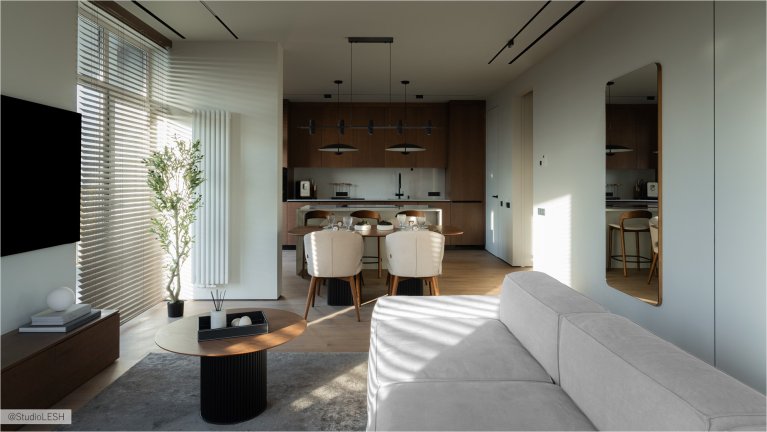 Уютная гостиная с мягким диваном, круглым журнальным столиком, обеденным столом со стульями и зеркалом, отражающим свет. В комнате также есть растение в горшке, добавляющее жизни и свежести