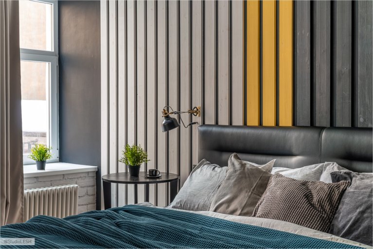 Современная спальня с деревянной панелью во главе кровати