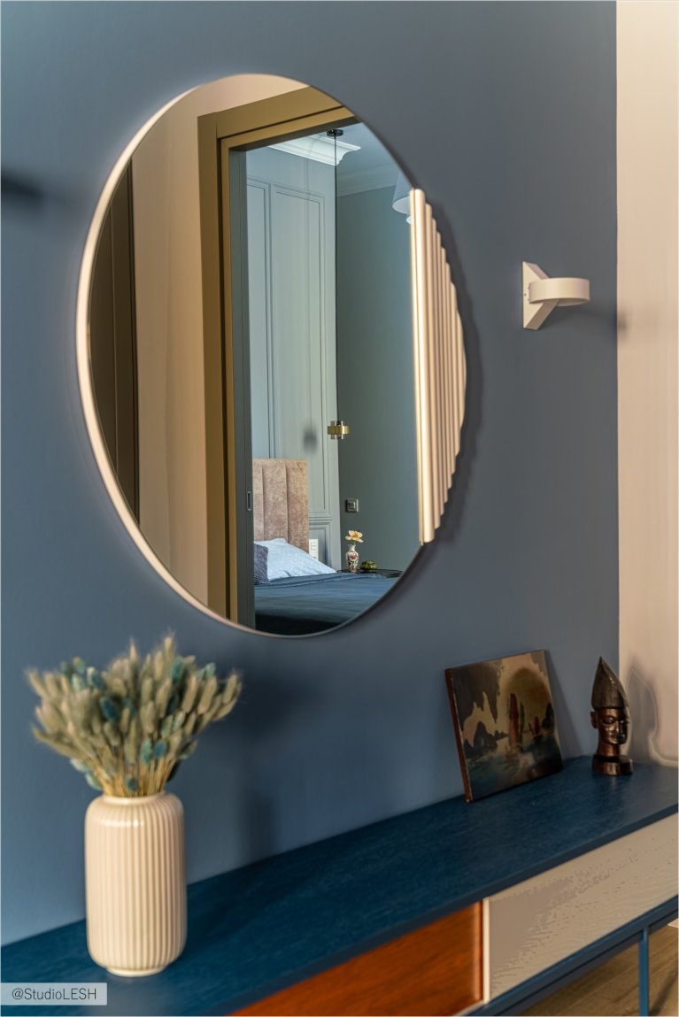 Тумба с выдвижными ящиками, украшенная вазой с сухоцветами, картиной и статуэткой