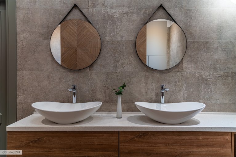 Две раковины, установленные на деревянной столешнице, обеспечивают удобство для двух пользователей