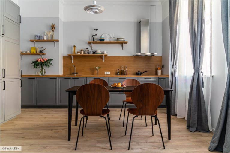 Серая кухонная мебель с интегрированными ручками и деревянными полками, создающая современный вид